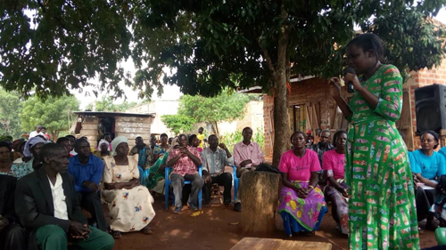 The woman with the microphone is the Assistant Chief Administrative office for Nakasongola district Mrs. Nakate Edith addressing community members in the dialogue.